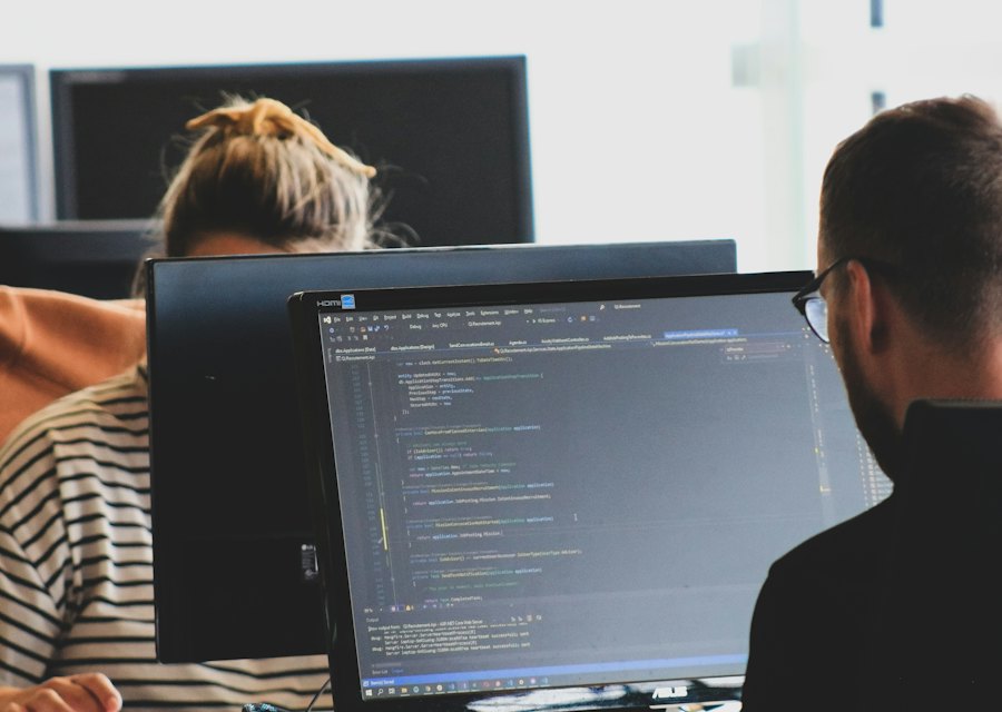 An engineer writing code on a monitor in a bright office